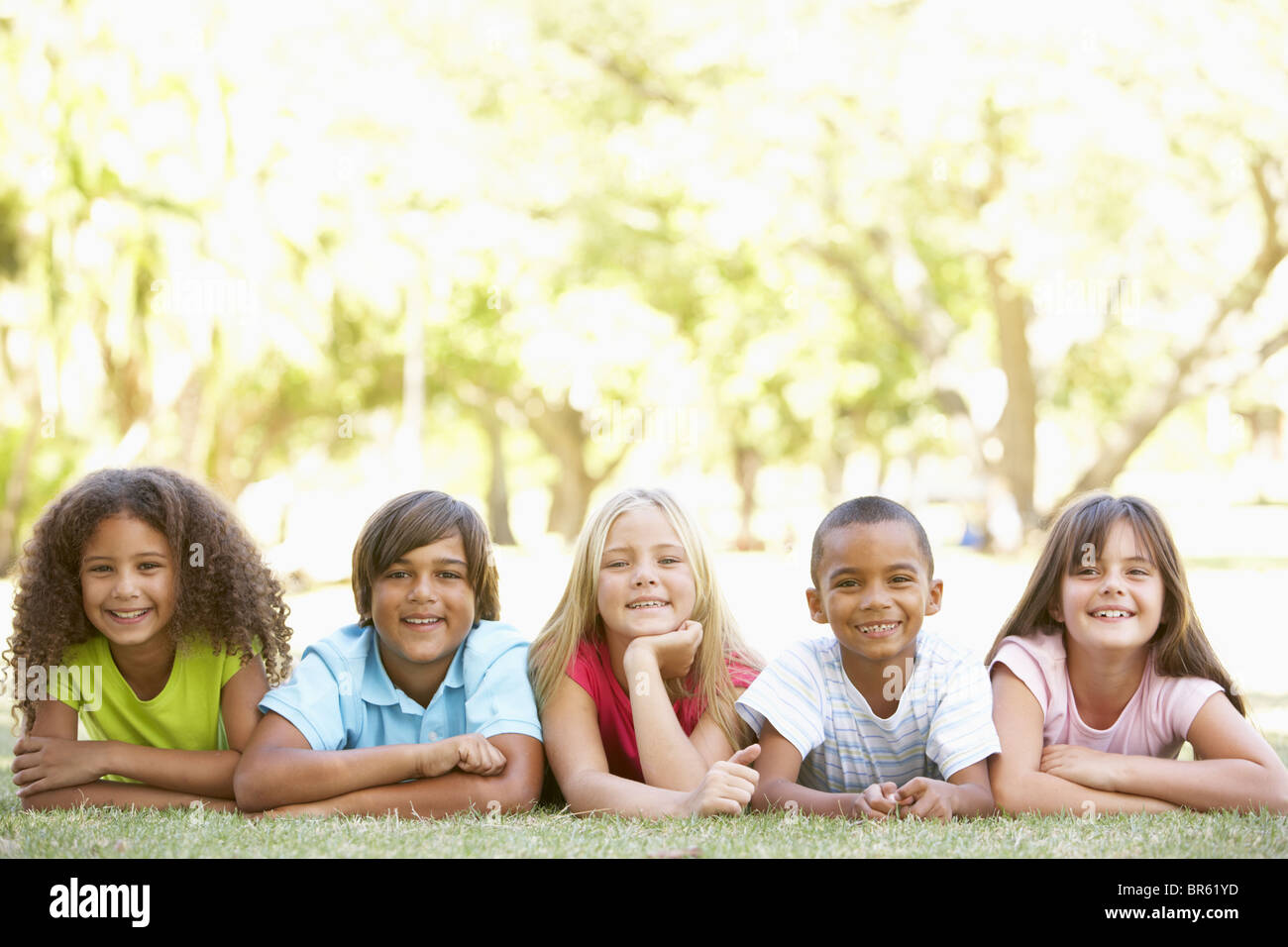 Gruppe von Kindern liegen auf Bauch im Park Stockfoto