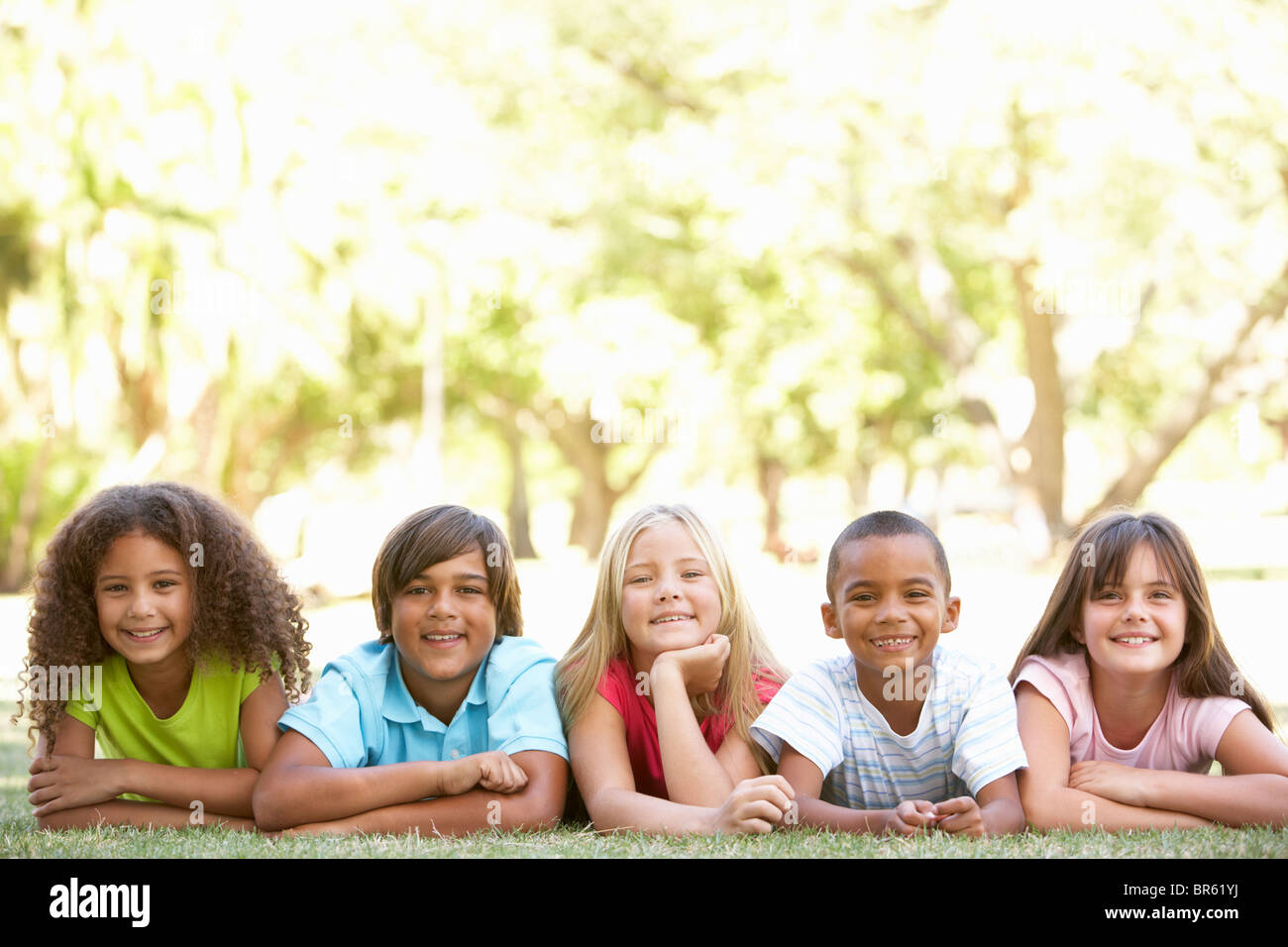 Gruppe von Kindern liegen auf Bauch im Park Stockfoto