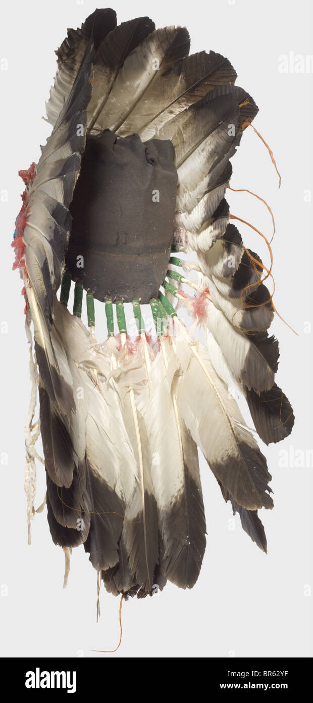 A Plains Indian war Bonnet, USA, Anfang des 20. Jahrhunderts. Eine Krone aus großen Adlerfedern, die untere mit rot gefärbten Daunenfedern verziert ist, die an einer Filzkappe befestigt sind. Die Stirnpartie ist mit farbigen Perlen bestickt. Höhe ca. 45 cm. Eine Kriegshaube wurde nur zu besonderen Anlässen getragen, die reichen Dekorationen berichteten von den siegreichen Kämpfen seines Besitzers. Allein die Adlerfedern waren sehr kostbar und hatten noch mehr Wert als gutes Pferd: Historisches, historisches Amerikanerchen, Amerika, Völkerkunde, Ethnie, Ethnie, Objekt, Objekte, Schnitten, Ausschneiden, Ausschneiden, Ausschneiden, Ware, Stockfoto