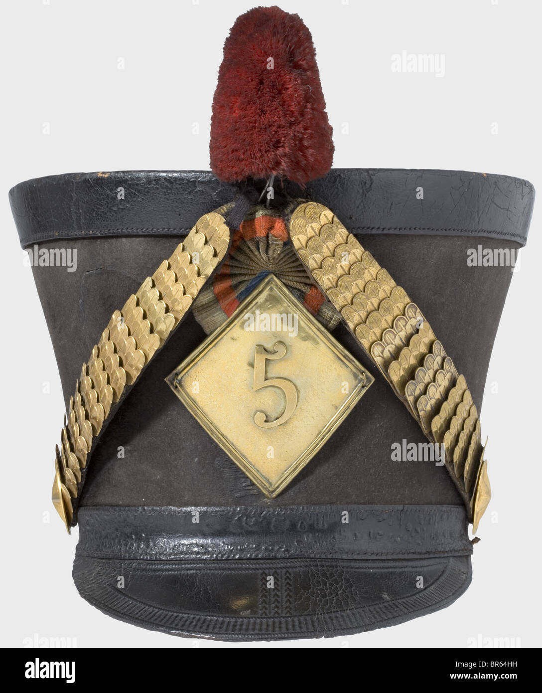 Ein Schako für Offiziere des 5. Hussaren-Regiments, gemäß der Verordnung von 1810. Großer, schwarzer Filzkörper (sichelförmige Rispe auf der Vorderseite). Verstellbares Kopfband und Visier aus schwarzem Leder mit Werkzeugschmuck. Blechchinskalen auf geprägten Sternrosetten. Rhomboidales, eingeprägtes Emblem gemäß der Verordnung von 1812 mit der Nummer "5". Lederkakade und Pflaume (Pompon fehlt). Leder-Sweatband und Leinenfutter. Band Leder und Sweatsband etwas gekappt. Alters- und Gebrauchsspuren. Das 5. Husaren-Regiment kämpfte in folgenden Gefechten: Eylau, Stockfoto