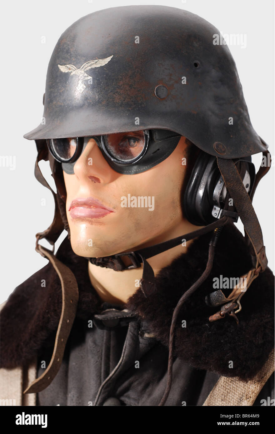 Ein einheitliches Ensemble für Luftwaffenschützen, EIN Schutzhelm des Fliegers, für Sammler mit Helm Des Typs 42. Grüne Schutzbrille aus Kunststoff mit getönten Linsen mit der Aufschrift "Auer Neophan". Ein Ohrhörer (defekt). Ein fliegender Anzug KW 1/33 blau mit braunem Schaffellkragen, Fleecefutter und gerader Knopfreihe. Alle Verschlüsse sind mit Knöpfen (feldgrau) statt mit Reißverschlüssen befestigt. Feldgraue Leinenhandschuhe mit einem Auslösefinger, grauer Lederausstattung und einem Stempel des Herstellers von 1941. Eine Straßenkarte für Nordfrankreich und England. Kartusche aus blauem Leinen, STA, Stockfoto