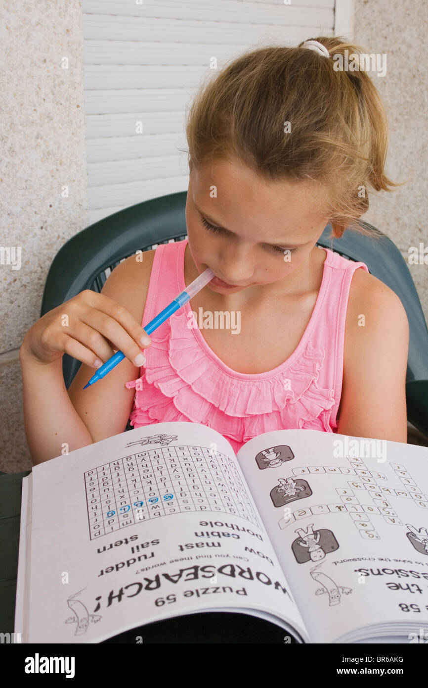 Zehn Jahre altes Mädchen Puzzle-Buch zu tun. Stockfoto