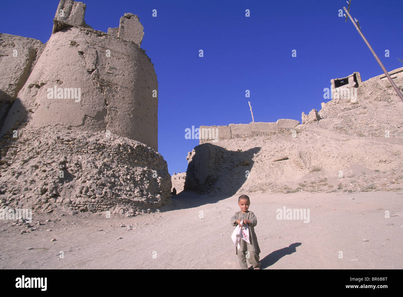 Ein Kind geht unterhalb der alten Mauern und die Zitadelle der Stadt von Ghazni Afghanistan Stockfoto