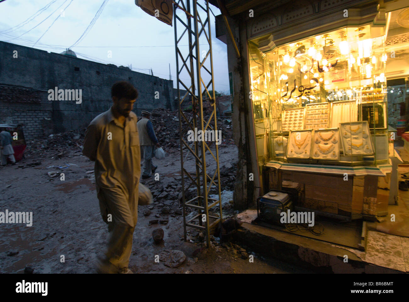 Ein Mann geht vorbei an einem Geschäft in Trümmern Muzaffarabad Pakistan Stockfoto