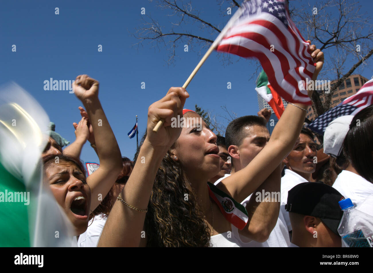 Demonstranten wave-amerikanische Flaggen und singen auf einer Kundgebung der Mai Tag für die Rechte der Einwanderer in Denver Colorado Stockfoto