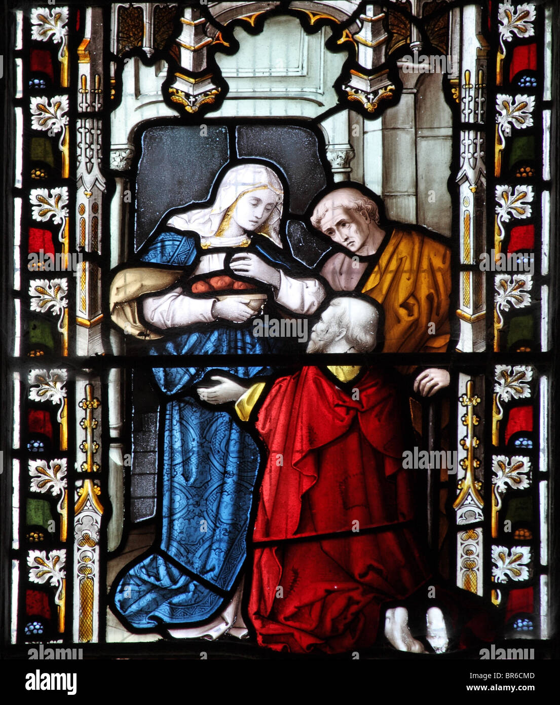 Ein Buntglasfenster von Lavern, Barraud & Westlake, das eine der Corporal Acts of Mercy darstellt; Fütterung der Hungrigen, Marhamchurch Church, Cornwall Stockfoto