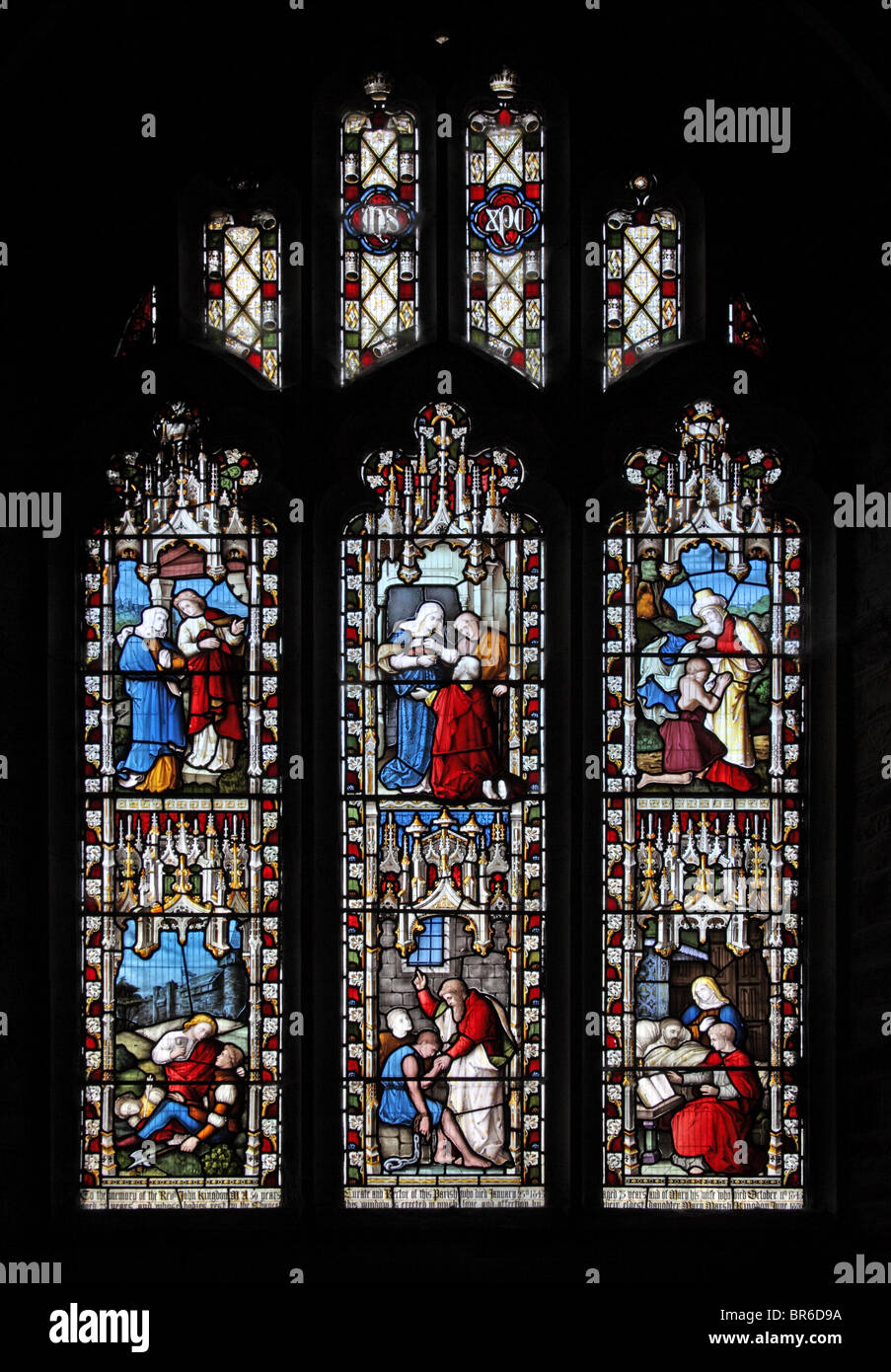 Ein Buntglasfenster aus dem Jahr 1870 von Laven, Barraud & Westlake, das Handlungen der korporalen Barmherzigkeit darstellt; Marhamchurch Church, Cornwall Stockfoto