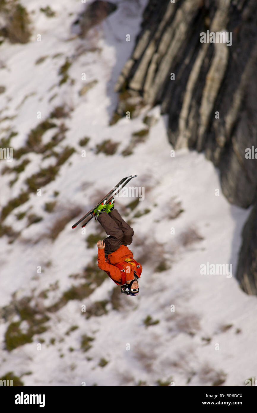 Ein männliche Ski BASE-Jumper springt ein 800 Fuß Granitklippe im Winter. Stockfoto