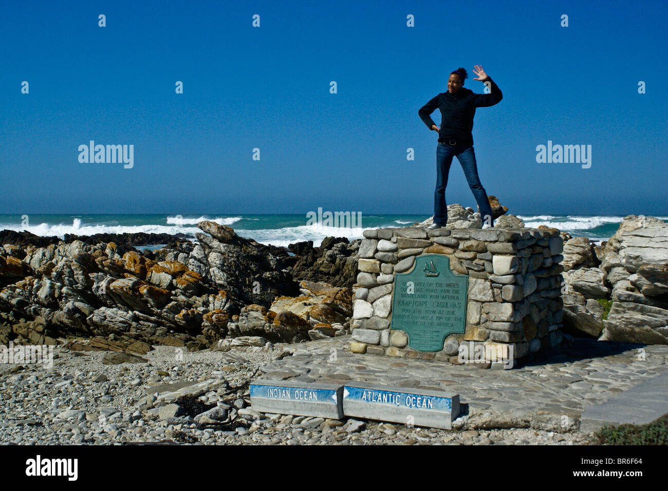Touristen stehen auf Denkmal am Kap Agulhas, Western Cape, Südafrika Stockfoto