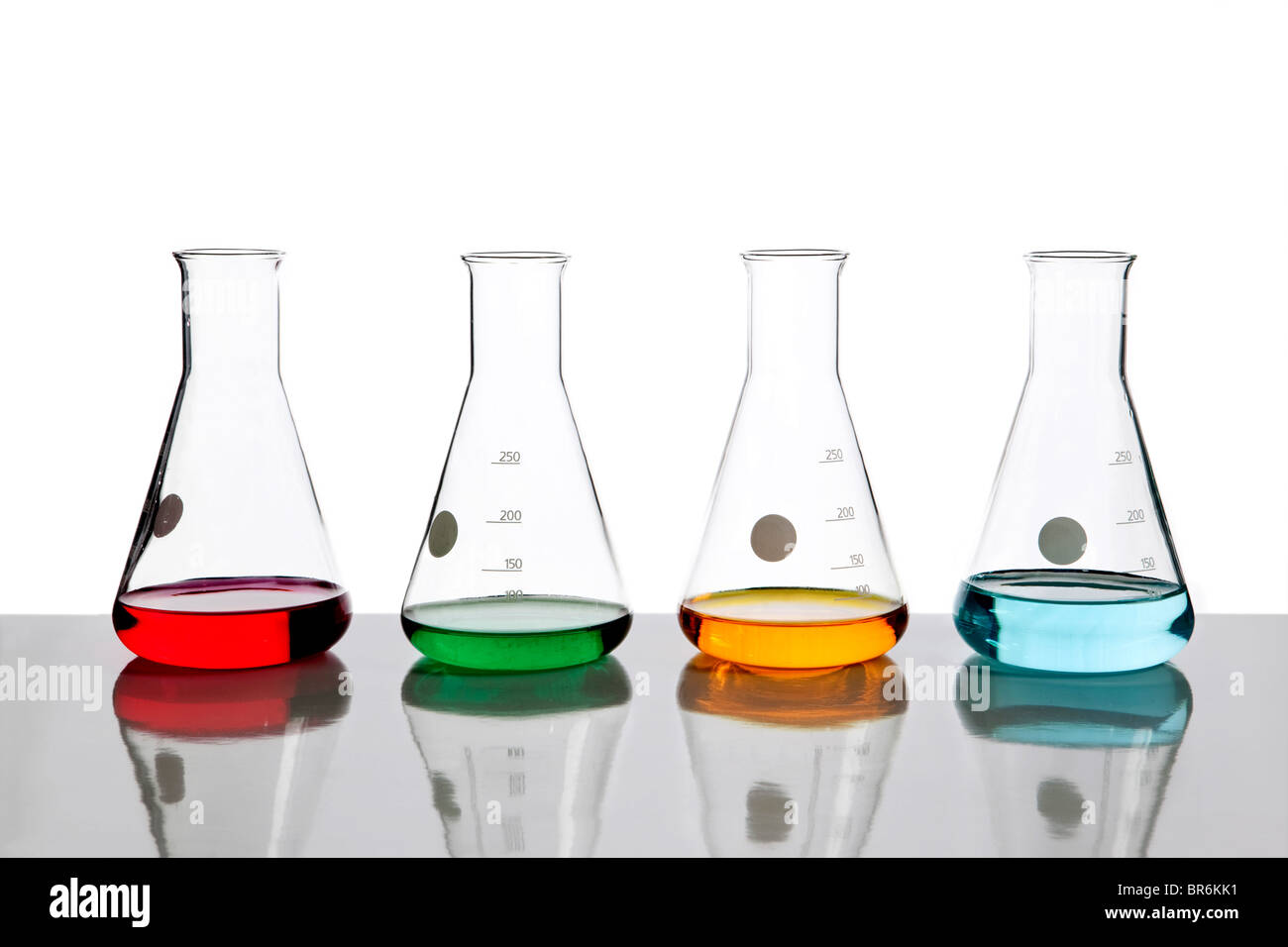 Vier konische Flaschen halten verschiedene farbige Flüssigkeiten Stockfoto