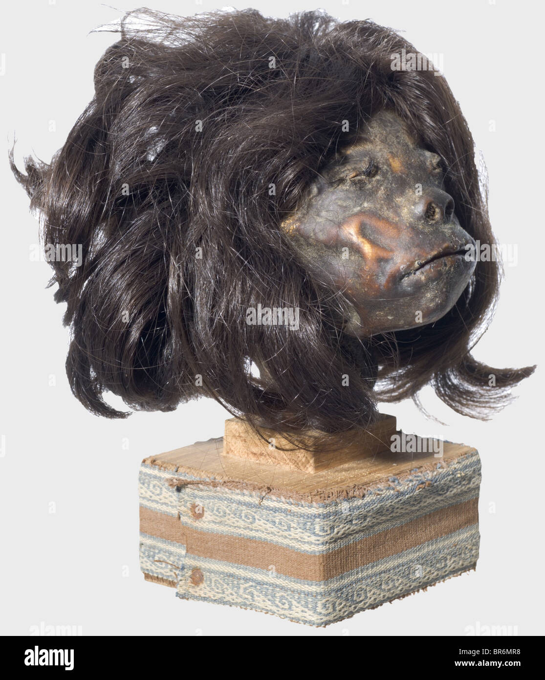 Ein schrunkener Kopf, Amazonas-Region. Halblanges, dunkelbraunes Haar, nicht abgenähte Augen, die Lippen mit Eindrücken und Resten der Nähschnur. Auf der Rückseite des Kopfes reicht eine lange Vorbereitungsnaht bis zur Krone. Im Rachenbereich zwei zusätzliche Nähte. Kopfhöhe 12 cm. Sehr gut erhaltenes Stück und ein eindrucksvoller Beweis für die Praxis der Kopfjagd unter den Indianerstämmen des Amazonasgebietes, die bis in die 1950er Jahre andauerte: Historisches, historisches 20. Jahrhundert, Amerikaner, Amerika, Völkerkunde, Ethnie, Ethnie, Objekt, Objekte, Ausschneiden, Ausschneiden, Schneiden, Stockfoto