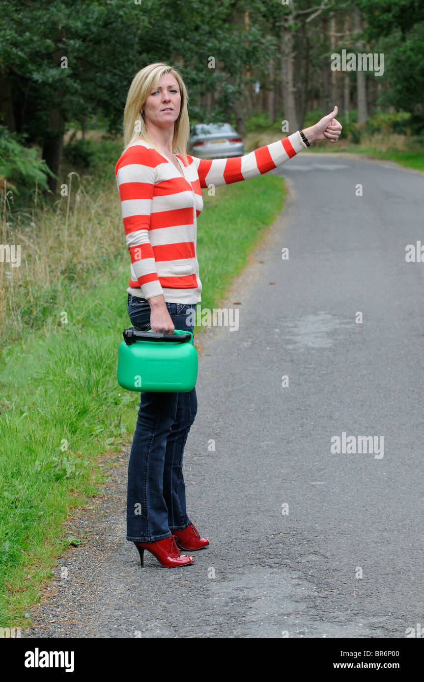 Weiblichen Autofahrer blätterte auf einen Feldweg hält ein 5-Liter-Benziner einen Aufzug kann Frau Autofahrer aus Kraftstoff heraus Stockfoto