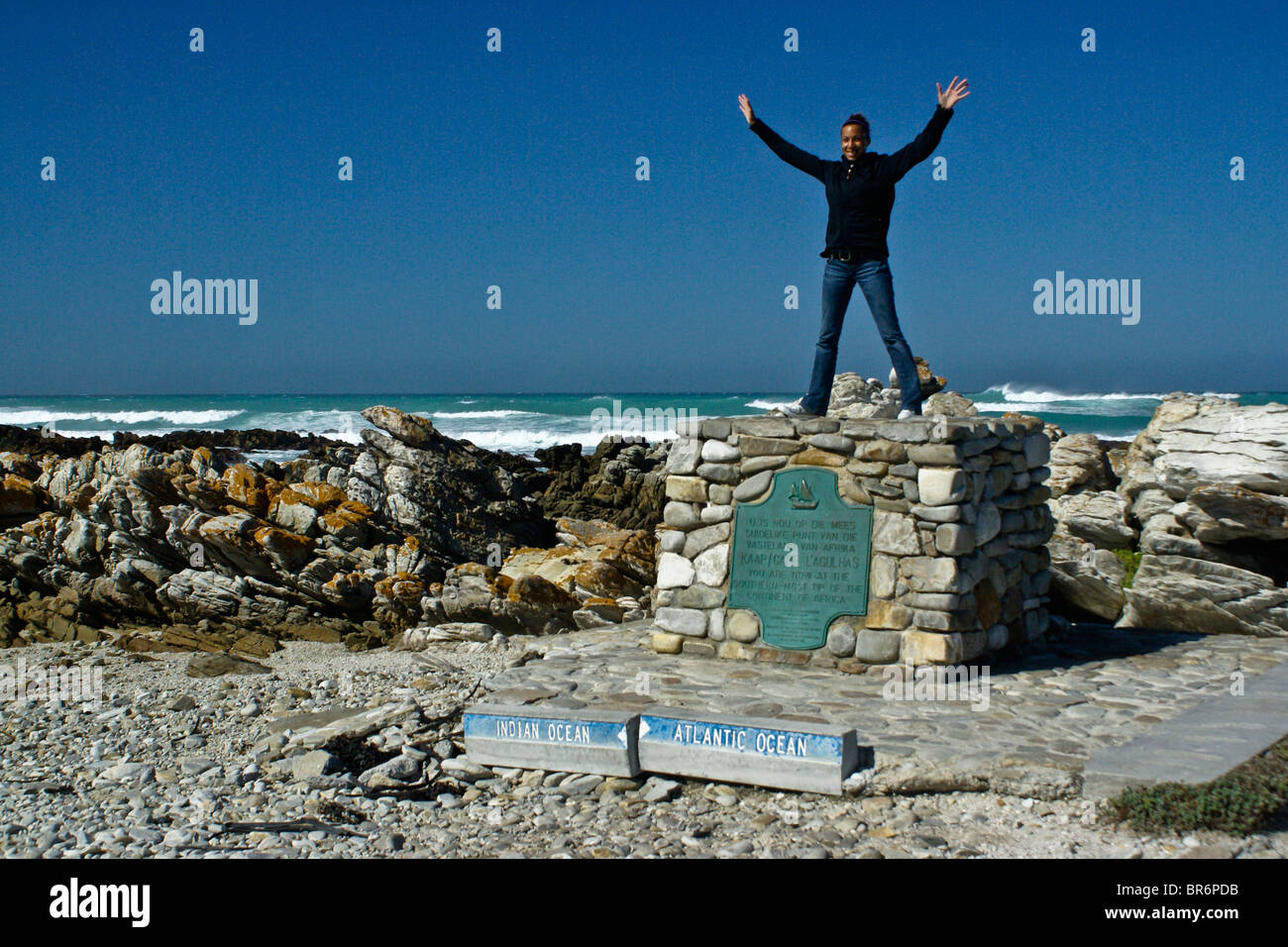 Touristen stehen auf Denkmal am Kap Agulhas, Western Cape, Südafrika Stockfoto