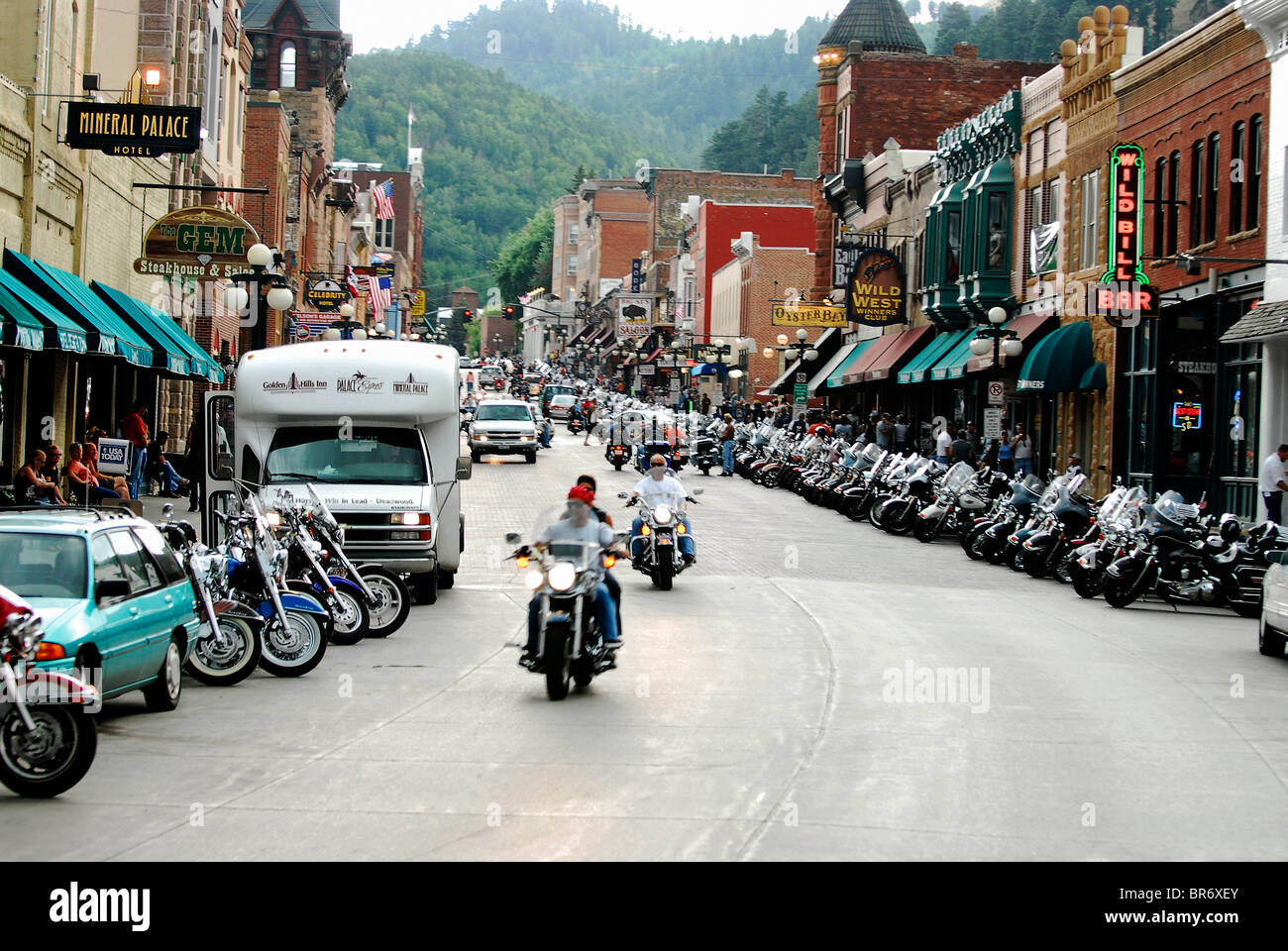 Zwei Motorräder gehen auf eine Straße gesäumt von Motorrädern auf der Sturgis Motorcycle Rally 2006 in Deadwood South Dakota. Stockfoto