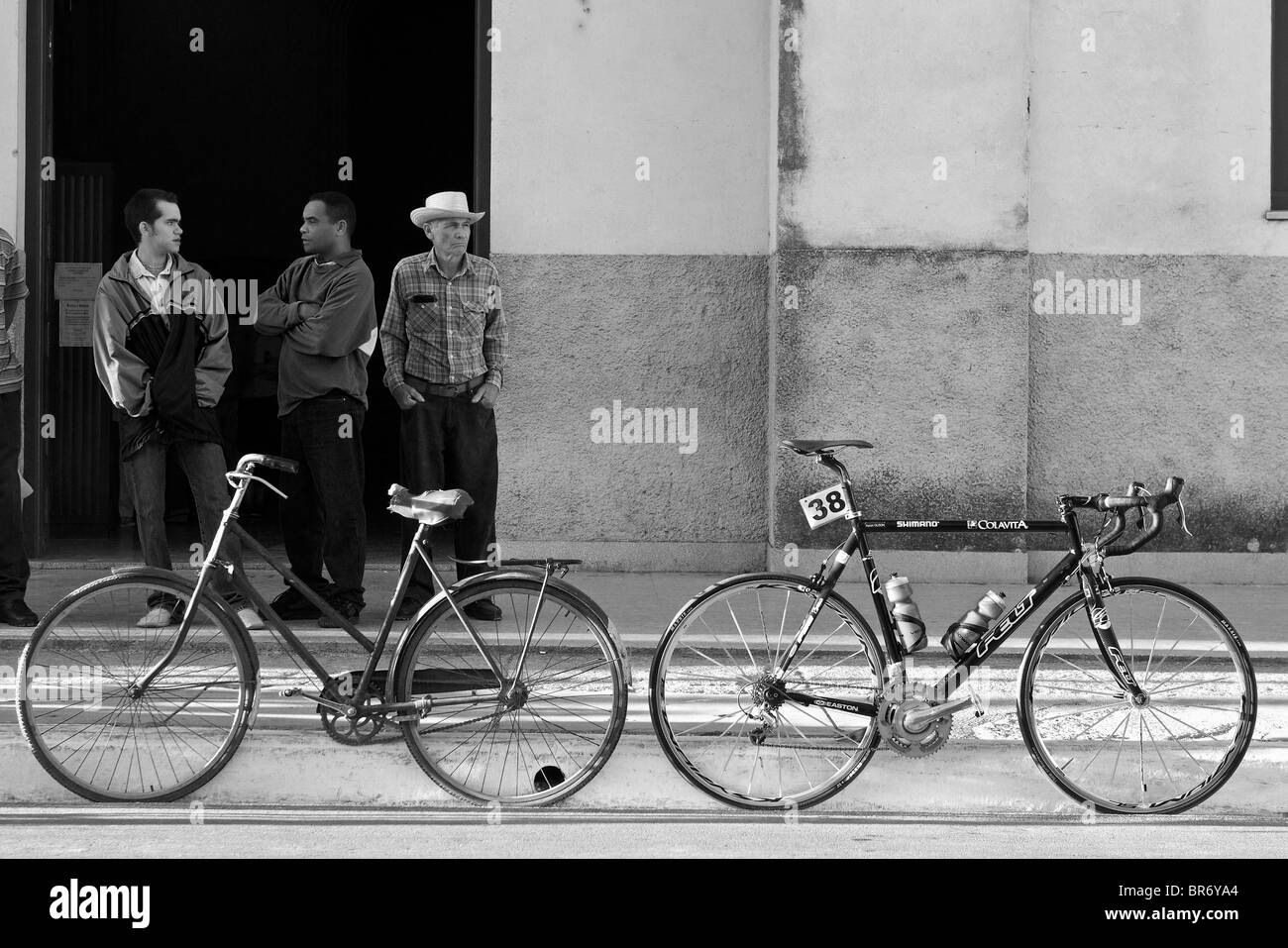 Zwei Rennräder stehen in der Nähe von drei Männern in Kuba. Stockfoto