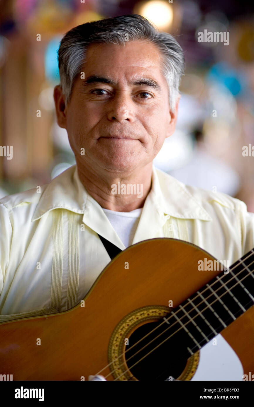 Ein Porträt von einem reifen Mann hält eine Gitarre in einem Restaurant in San Antonio, Texas. Stockfoto