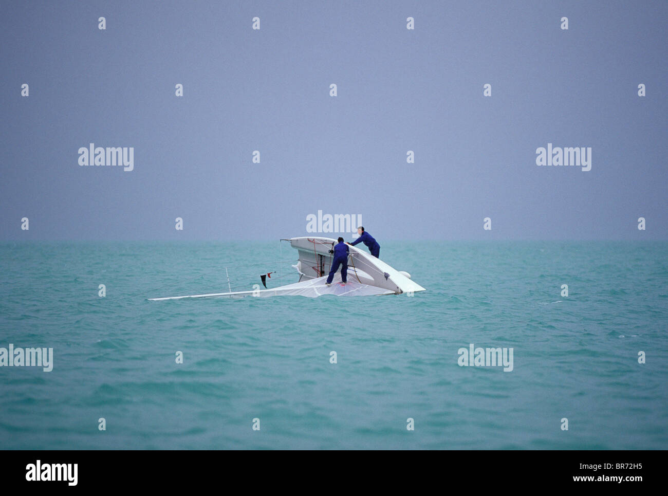 Mannschaft steht auf dem Kiel von einem gekenterten Melges 24 während der Rennwoche Key West, Florida, USA. Stockfoto