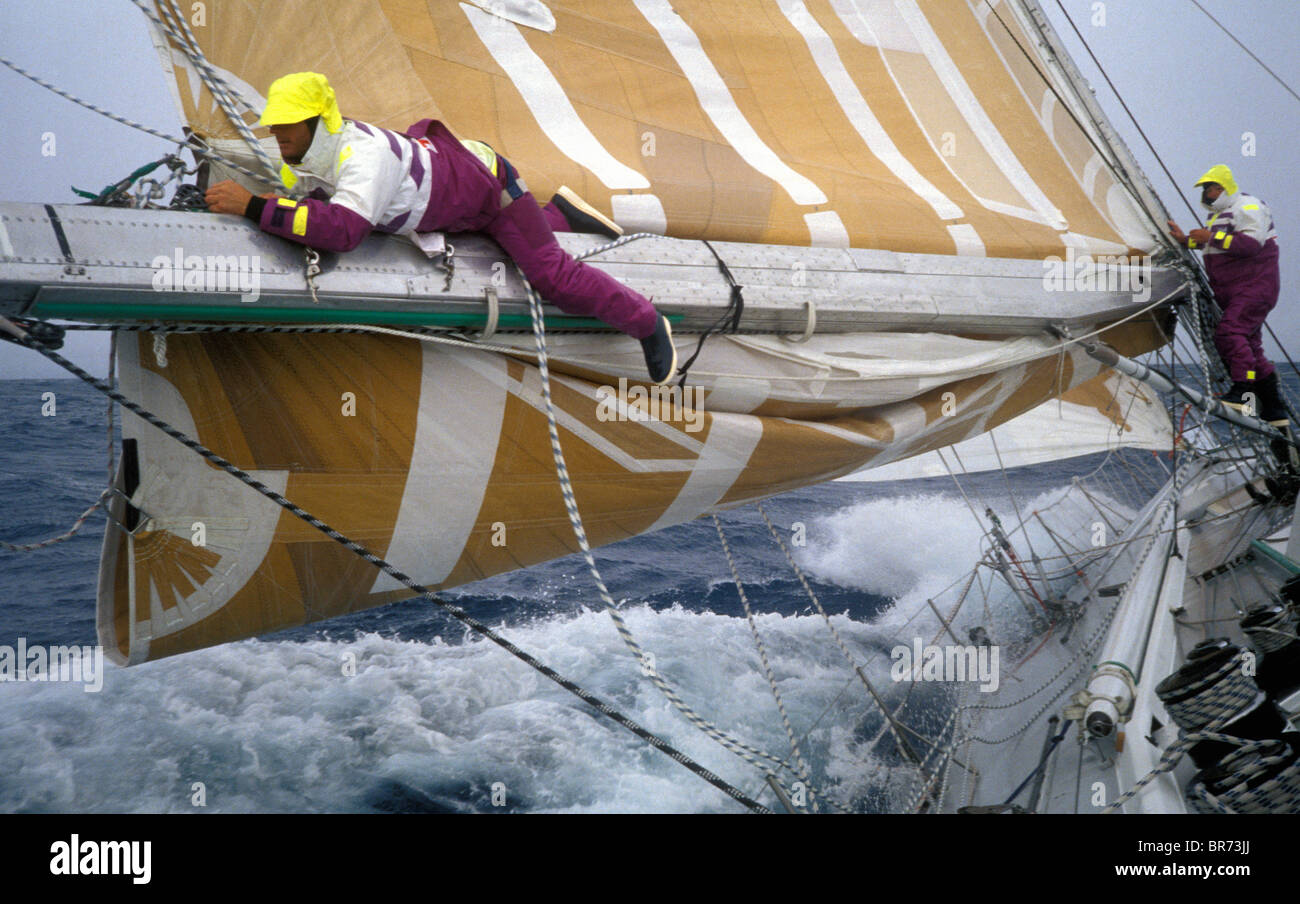 Crew-Mitglied steigt bis zum Ende des Booms zu entwirren die Reffen Linien an Bord "The Card" in den Whitbread Round the World Race, Stockfoto