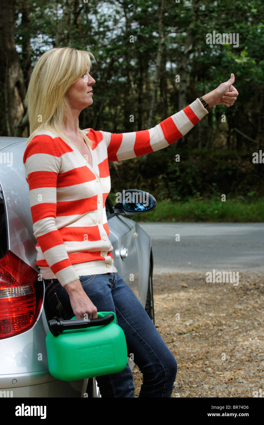 Weiblichen Autofahrer blätterte auf einen Feldweg hält ein 5-Liter-Benziner einen Aufzug kann Frau Autofahrer aus Kraftstoff heraus Stockfoto