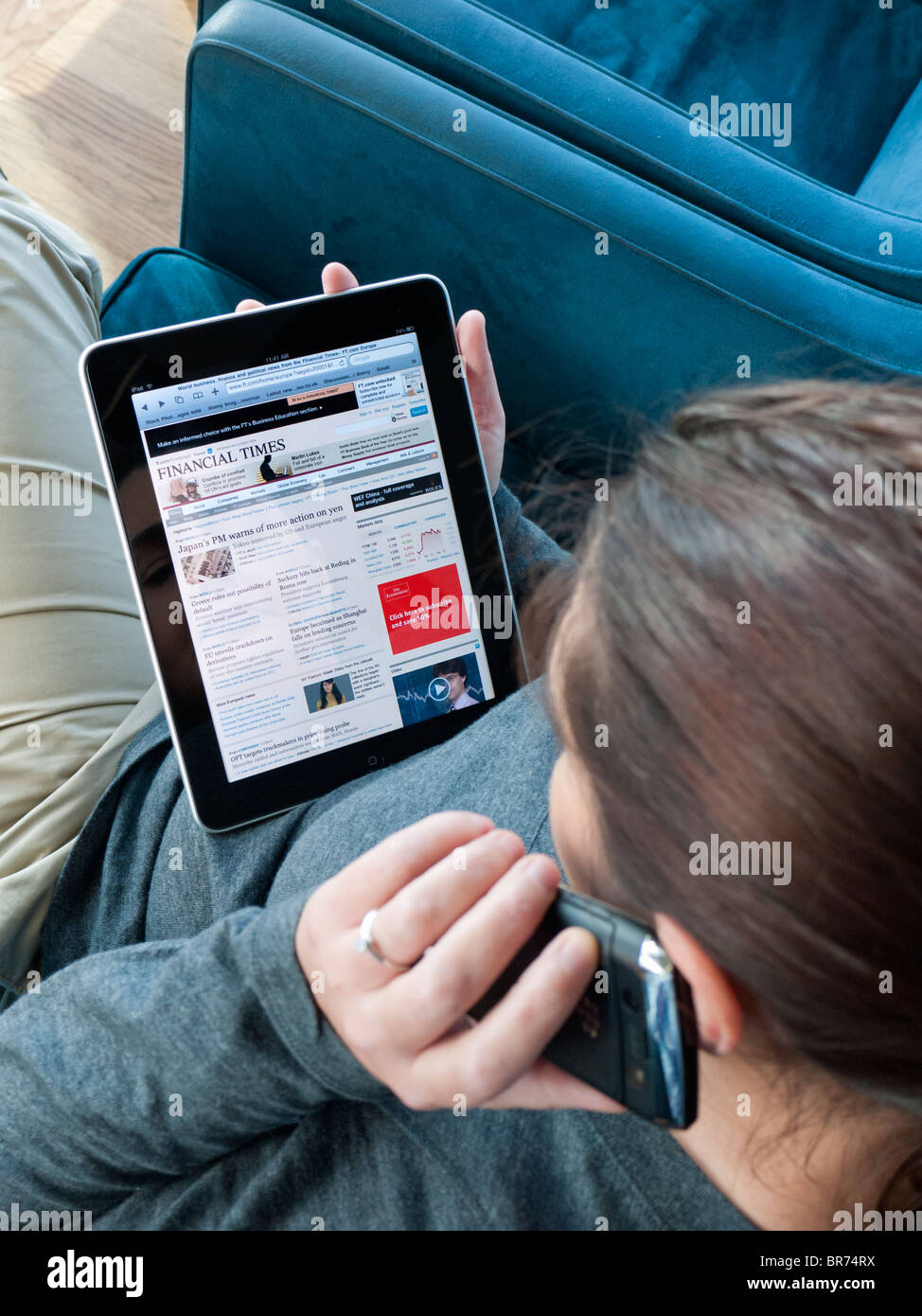 Frau mit iPad Computertisch in Flughafen Abflughalle Wirtschaftszeitung Financial Times lesen Stockfoto