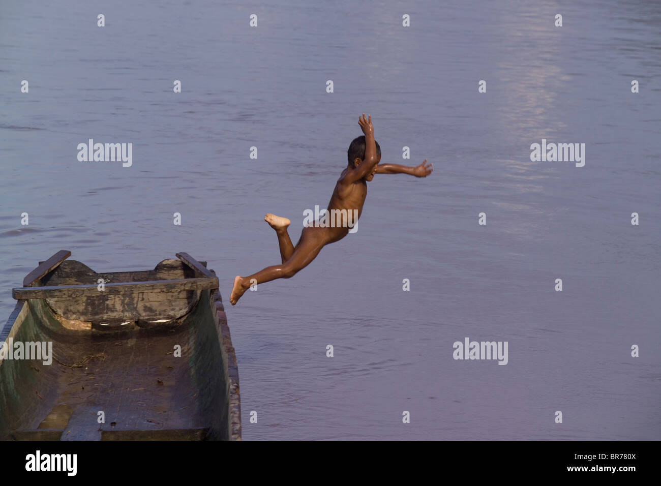 Ein kleiner Junge springt aus einem traditionellen Einbaum Miskito in Rio Coco in Nicaragua Krin Krin. Stockfoto