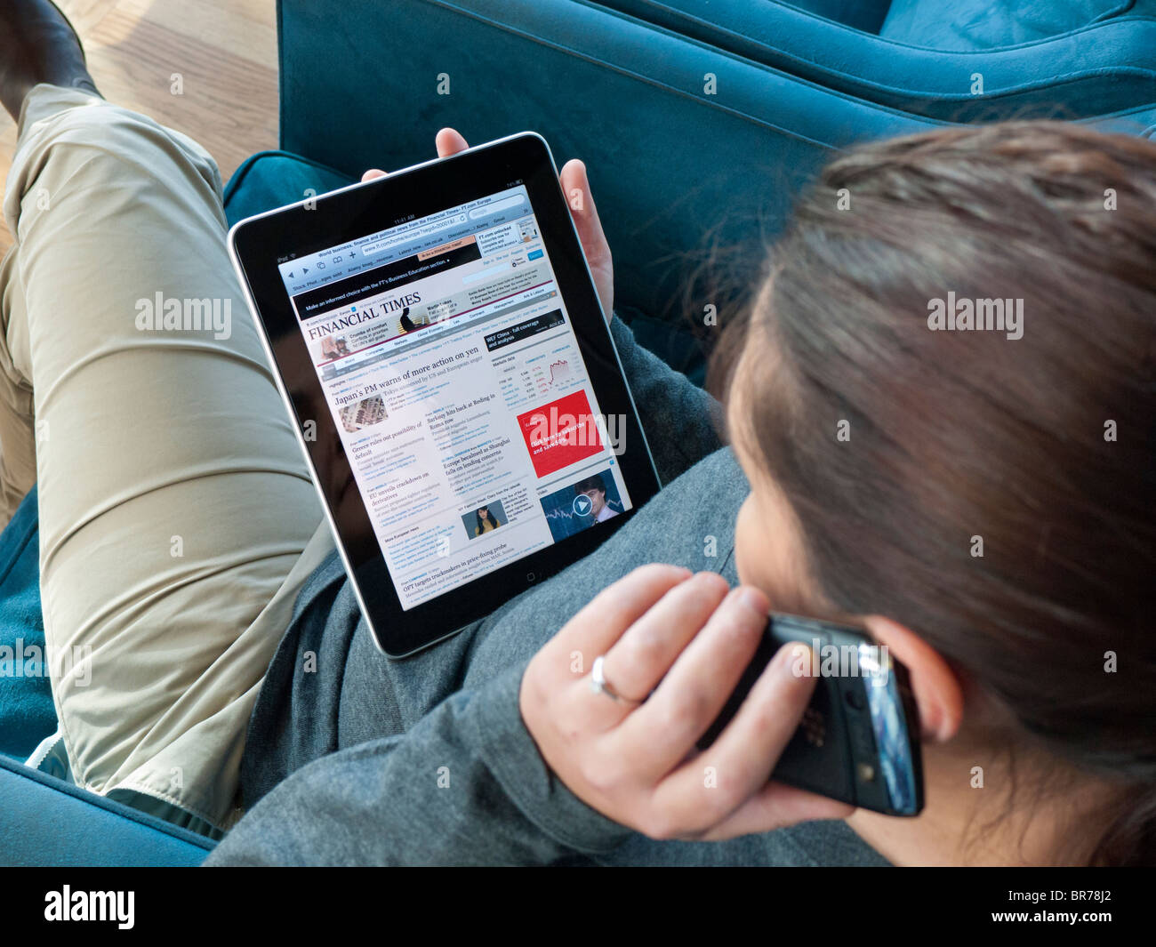 Frau mit iPad Computertisch in Flughafen Abflughalle Wirtschaftszeitung Financial Times lesen Stockfoto