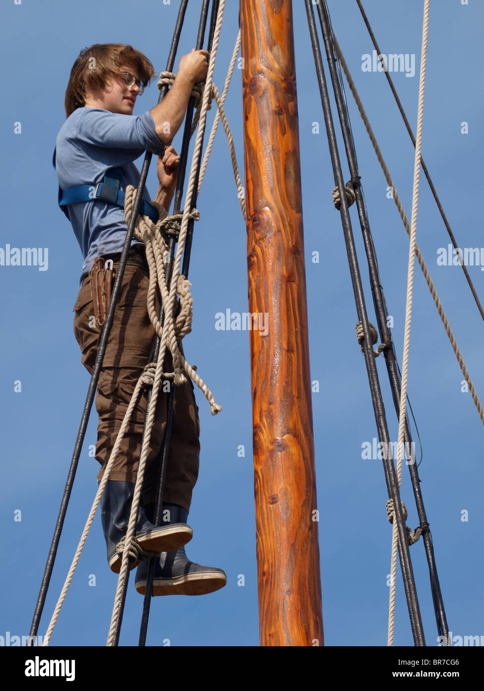 Junger Mann, die Aufarbeitung der Takelage ein altes Holzschiff, Cornwall, UK Stockfoto