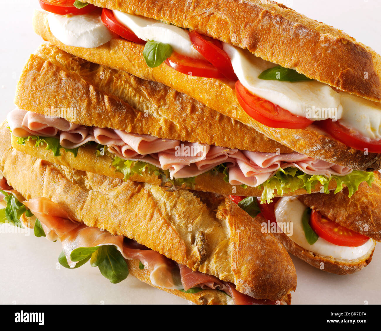 Baguette Brot gefüllt mit Mozerella & Tomaten, Schinken & Salat, Prcutto Schinken & Rakete. Stockfoto