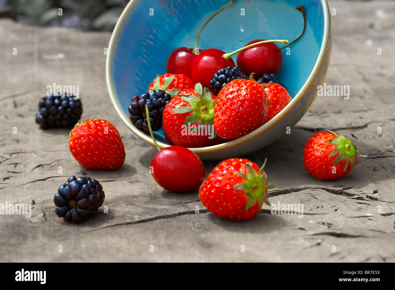 Schale mit frischem abgeholt Sommer Beeren auf einem hölzernen Tisch, Kirsche, Erdbeere und Blackberry Stockfoto