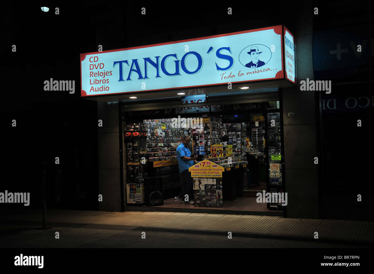 Nacht erschossen von einem älteren Mann, der Blick auf eine DVD in einem kleinen, offener Vorderseite Musikgeschäft, benannt "Tango", Lavalle, Buenos Aires Stockfoto