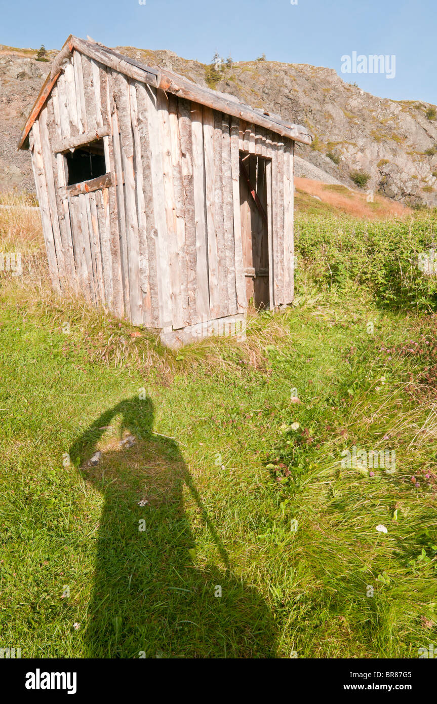 Alte hölzerne Hütte, Trinity, Neufundland und Labrador, Kanada; mit langen Schatten des Fotografen Stockfoto
