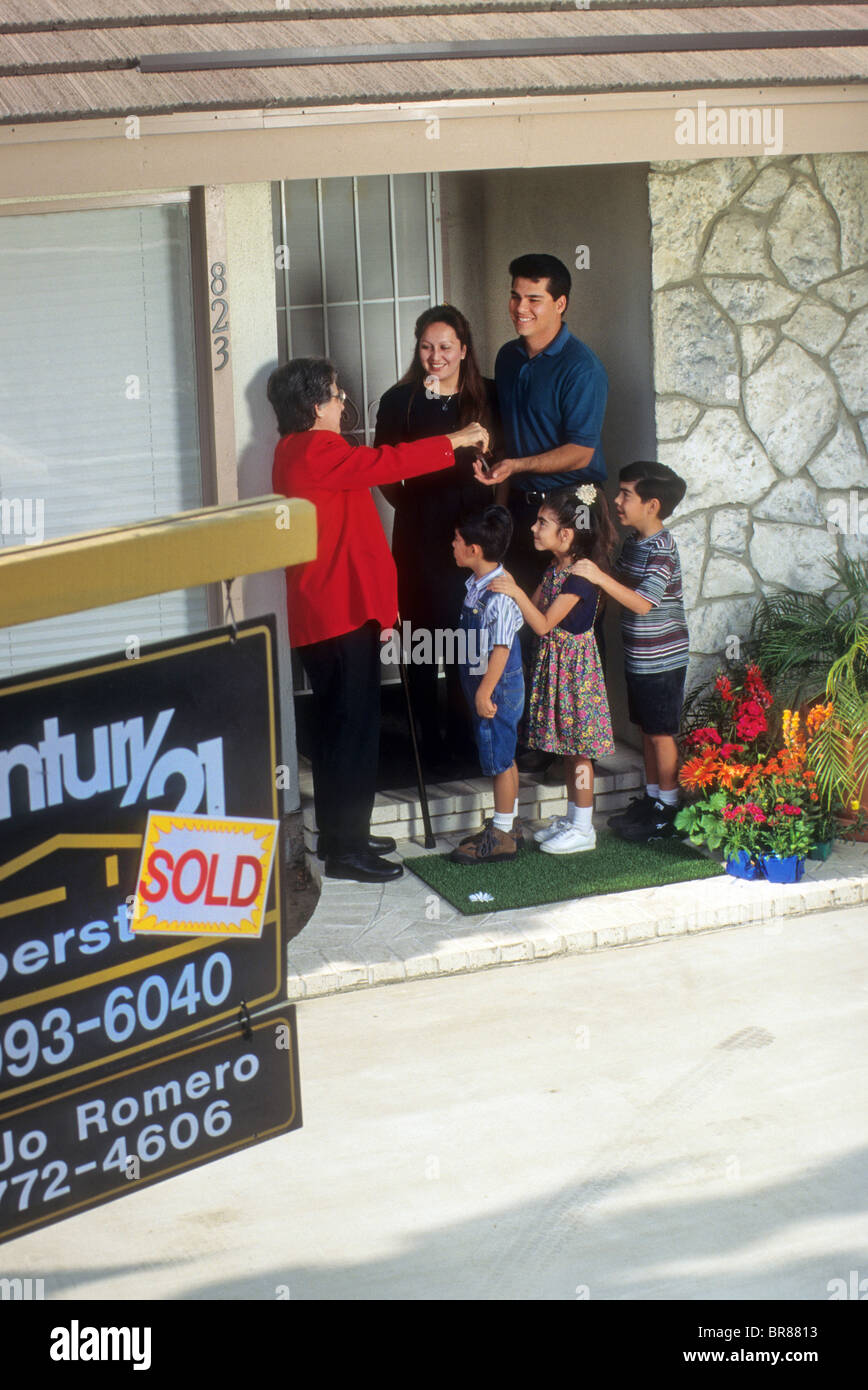 Haus Verkauf Familie stolz glücklich Sonderveranstaltung lieben Mann Frau paar kaufte Kinder Kinder jungen Mädchen Hispanic verkaufen Verkauf kaufen Stockfoto