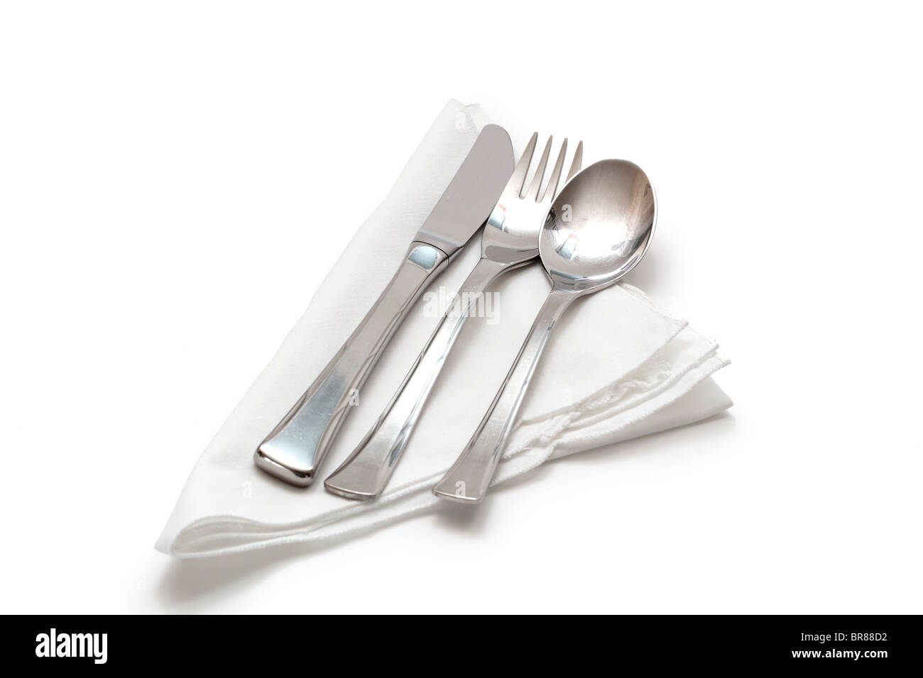 Messer, Gabel und Löffel auf einer weißen Baumwoll-Serviette Stockfoto
