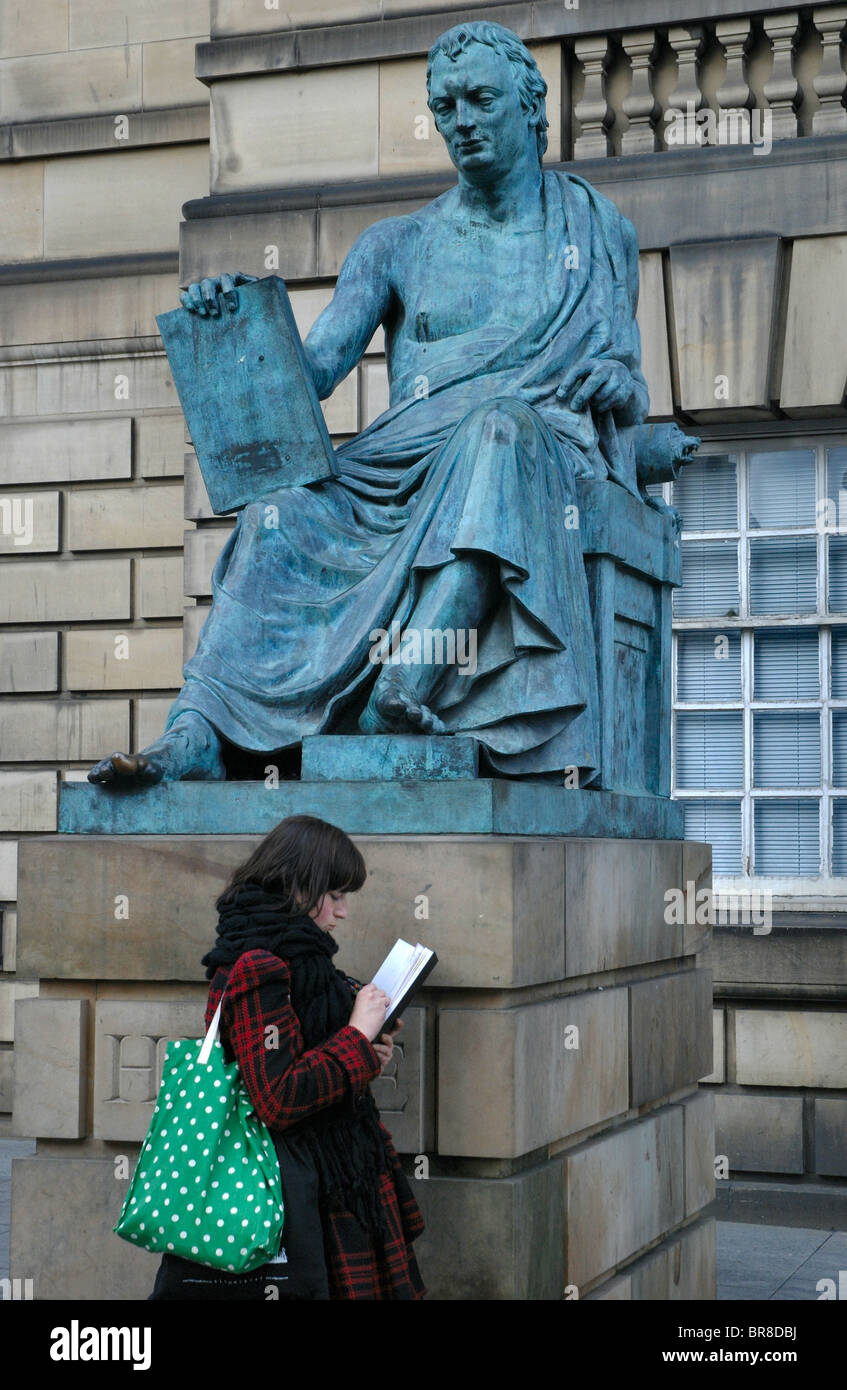 Eine Mädchen skizziert neben der Statue von David Hume auf der High Street in Edinburgh, Schottland. Stockfoto