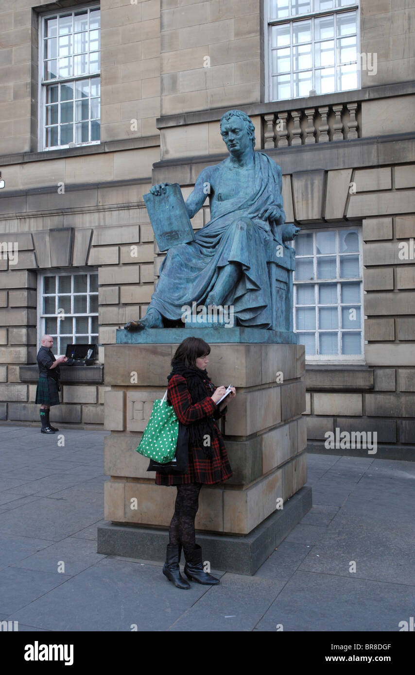 Ein Mädchen an der High Street in Edinburgh neben der Statue des Philosophen und Historiker David Hume skizzieren Stockfoto