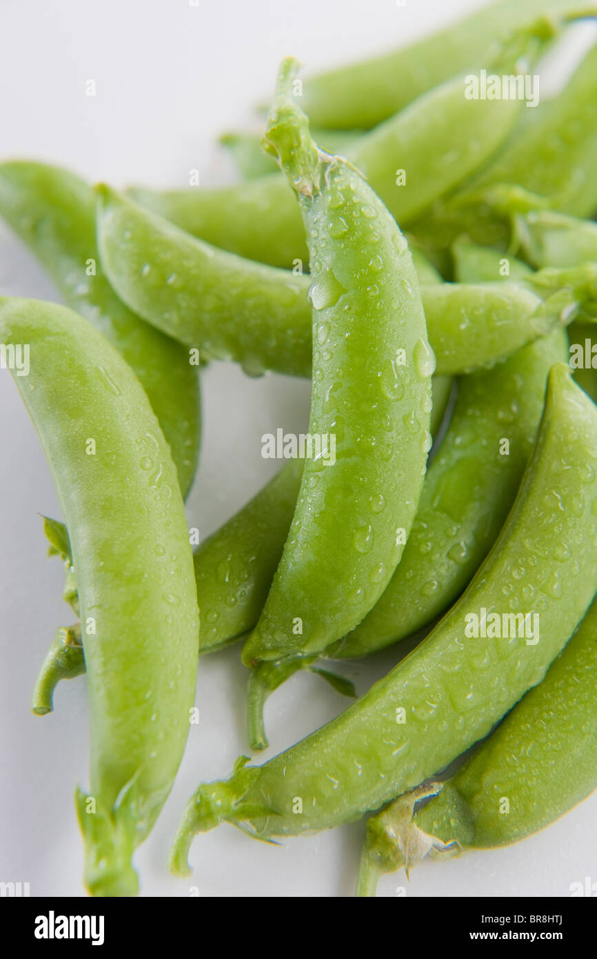 Snap Erbsen mit Wassertropfen, Nahaufnahme, weißer Hintergrund Stockfoto