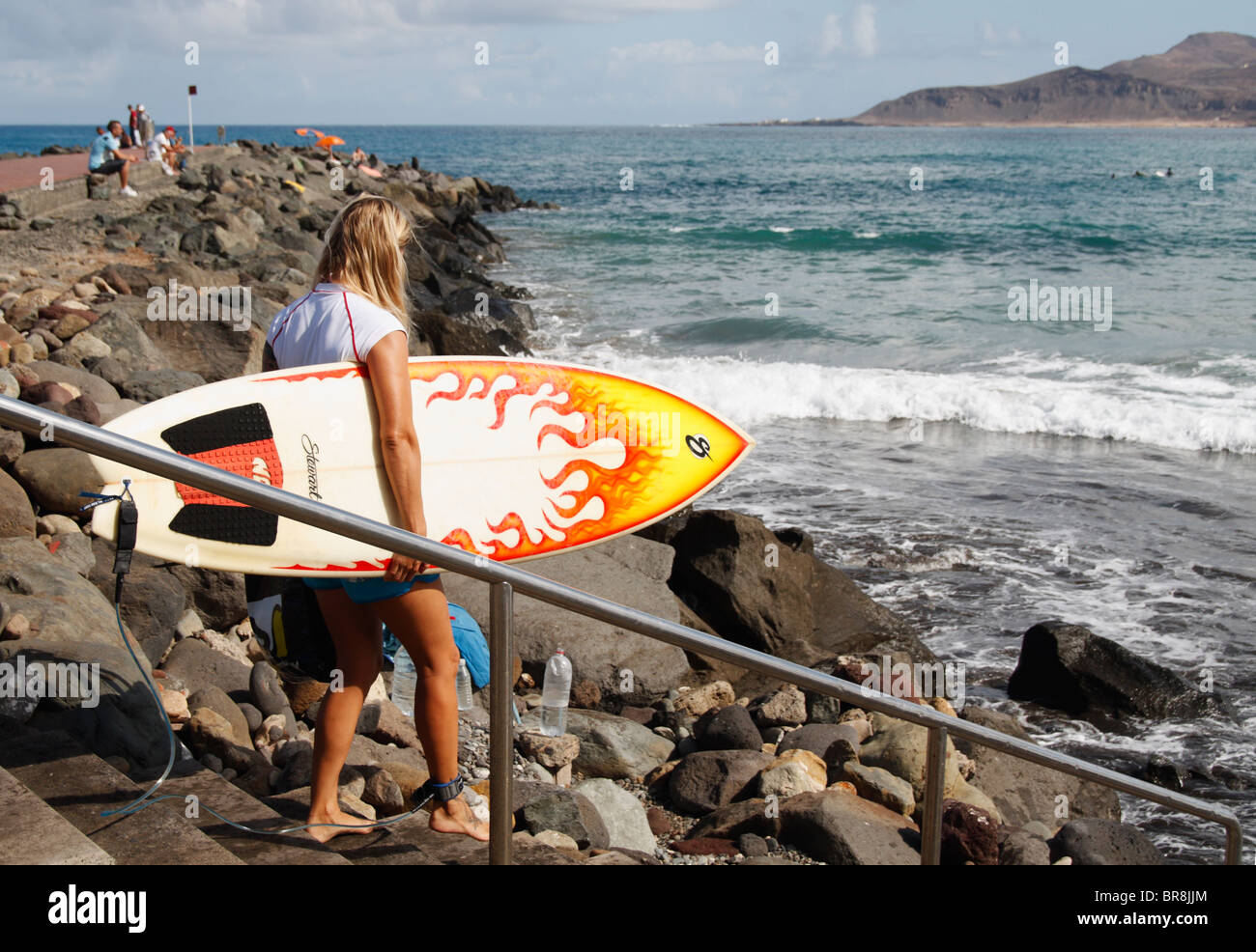 Blonde weibliche Surfer mit Surfbrett Stockfoto