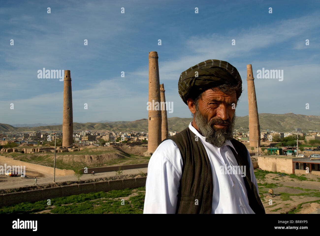 Ein Wachmann an Königin Gawhar Shad Mausoleum steht vor vier hohen Minarette, einst Teil der Madrassa, die in 1 gebaut wurde Stockfoto