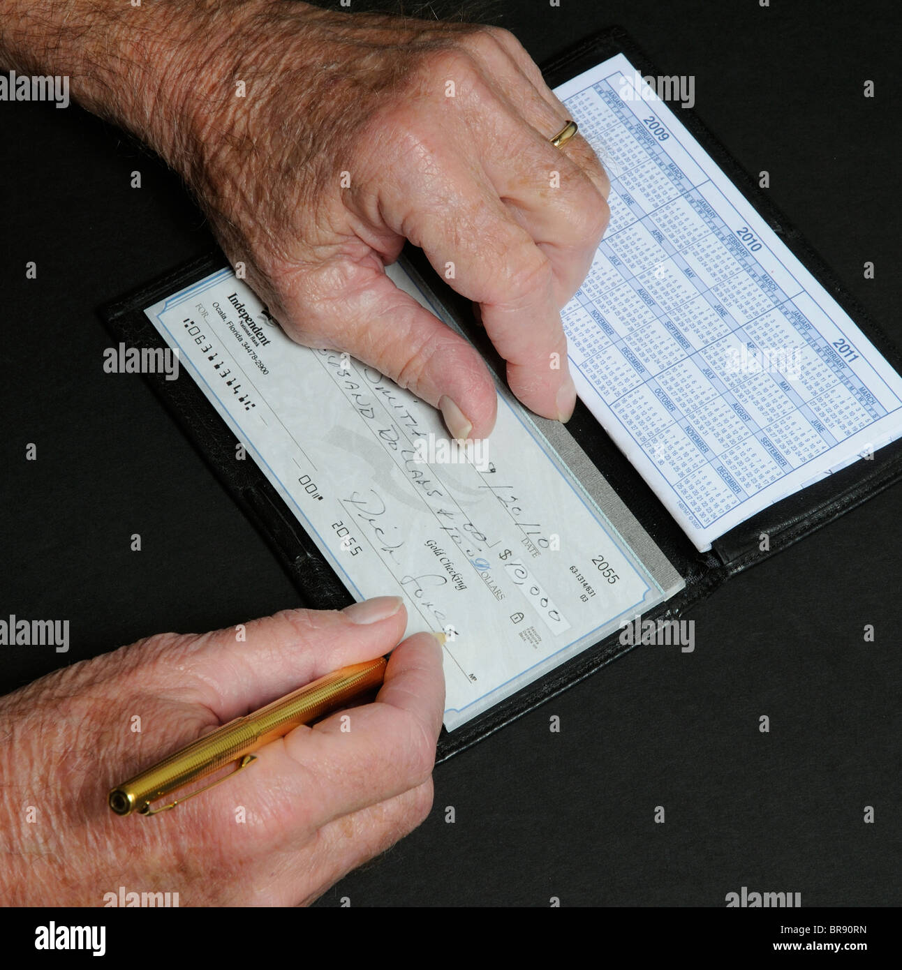 Ältere Menschen mans Hände schreiben zehn tausend-Dollar-Scheck aus unabhängigen National Bank Florida USA Stockfoto