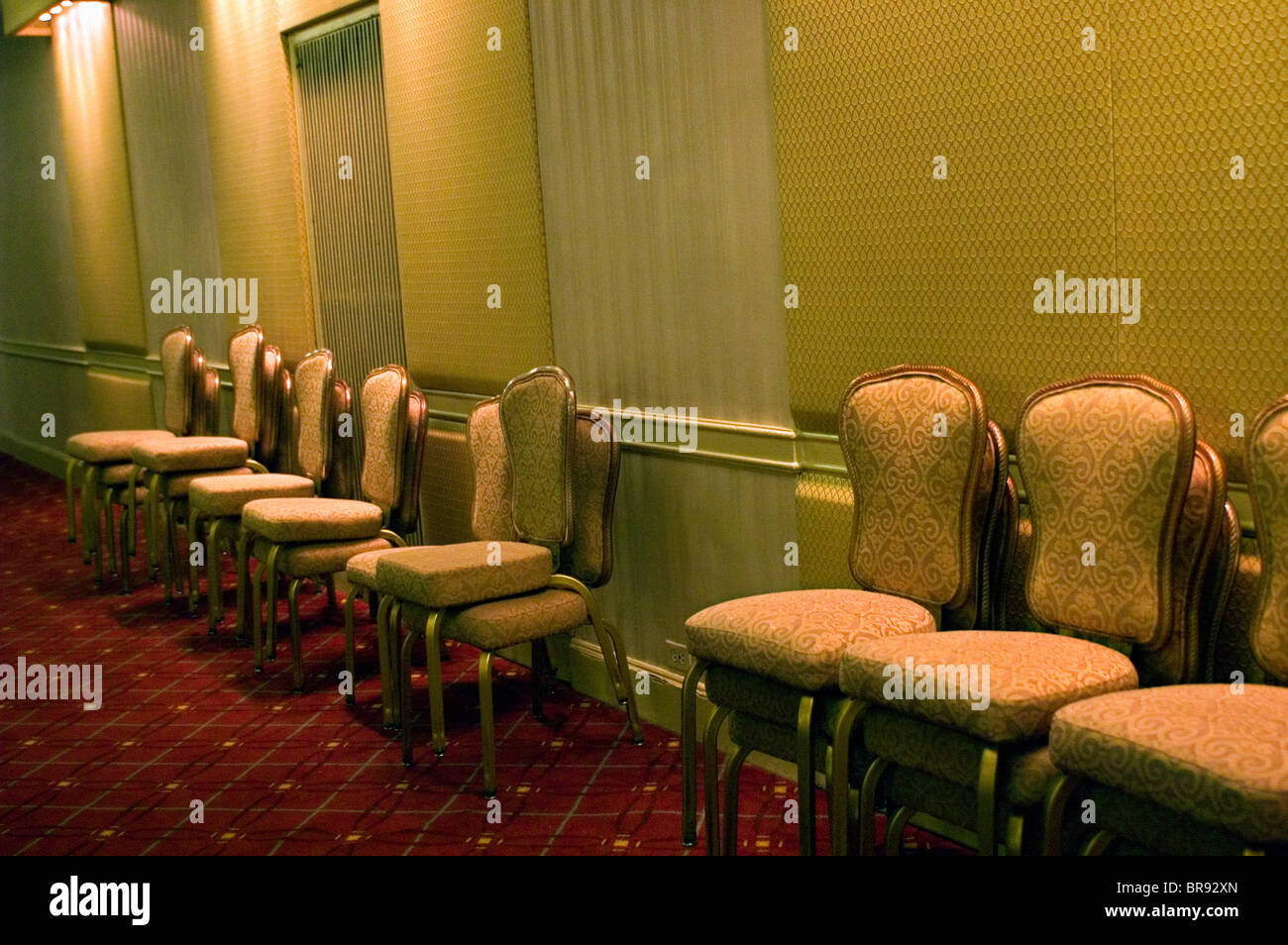 leere Stühle werden in einer Konferenz Zimmer Umgebung gestapelt. Stockfoto