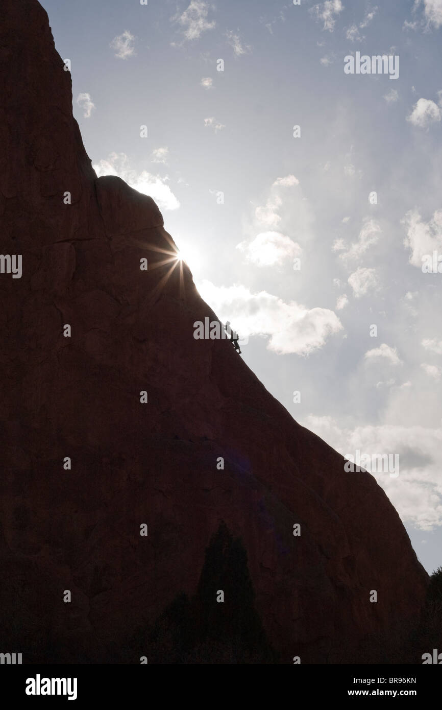 Mann besteigt Rock Berg in Richtung Sonne Stockfoto