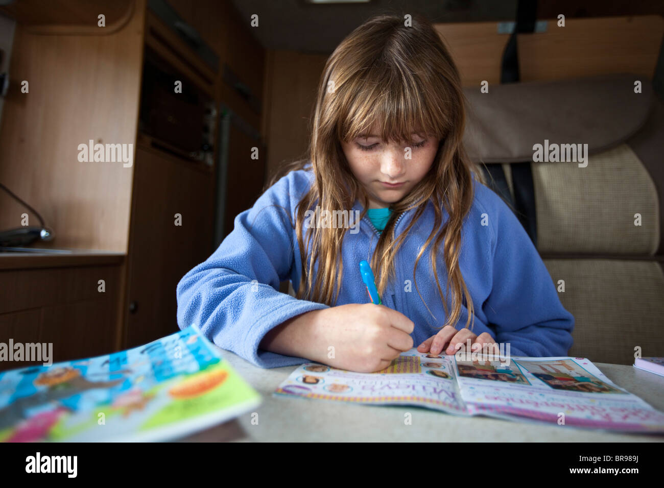 Teenager-Mädchen machen ein Puzzle-Buch während des Urlaubs in einem Wohnwagen im Vereinigten Königreich Stockfoto