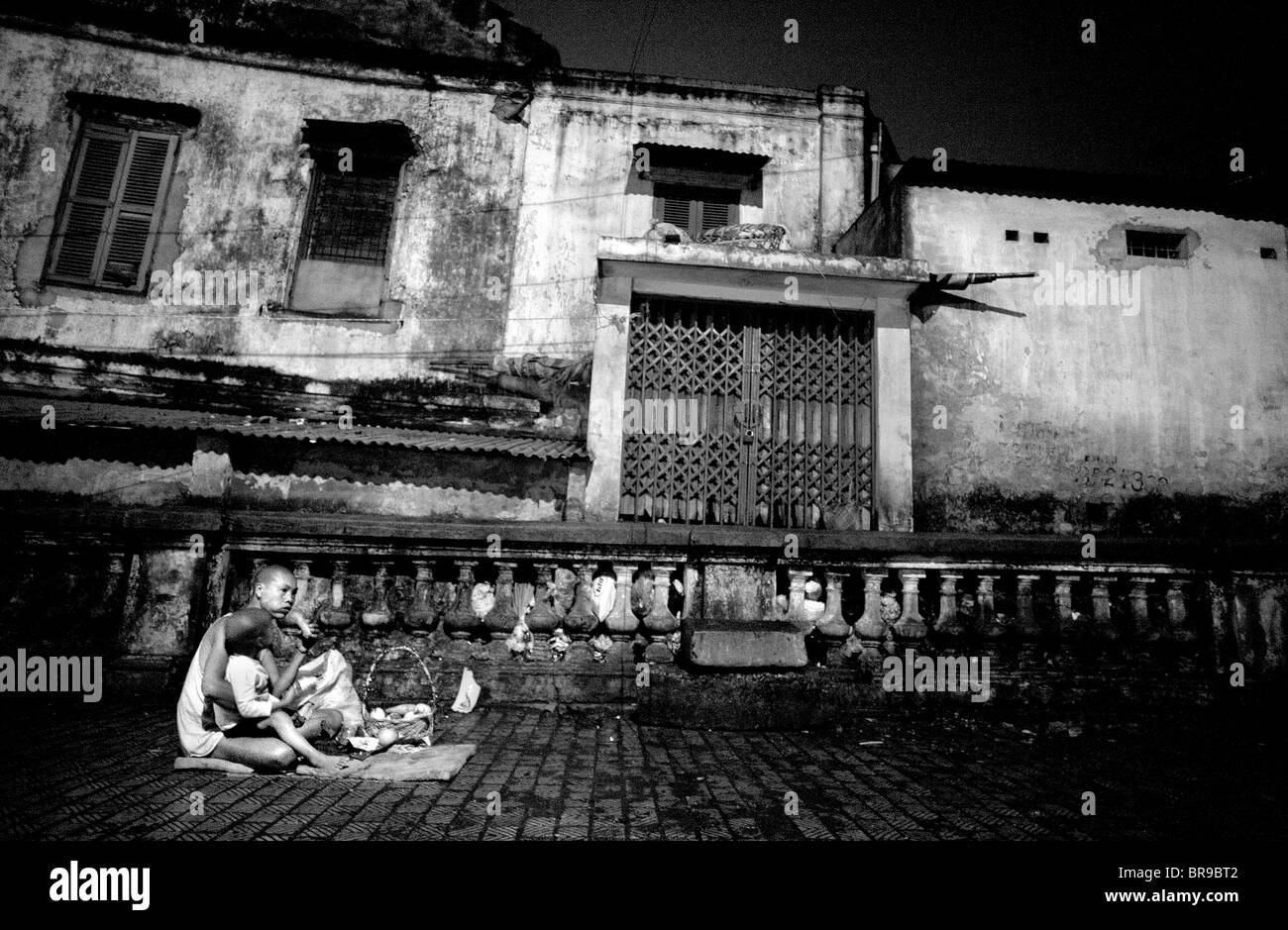 Sohn sitzt auf Mutters Schoß beim Abendessen in Hanoi auf. Stockfoto