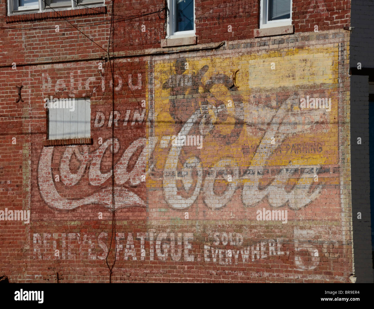 Sehr alte Werbung für Coca-Cola und Yamaha Motorräder auf Seite von einem alten Backsteingebäude gemalt. Stockfoto