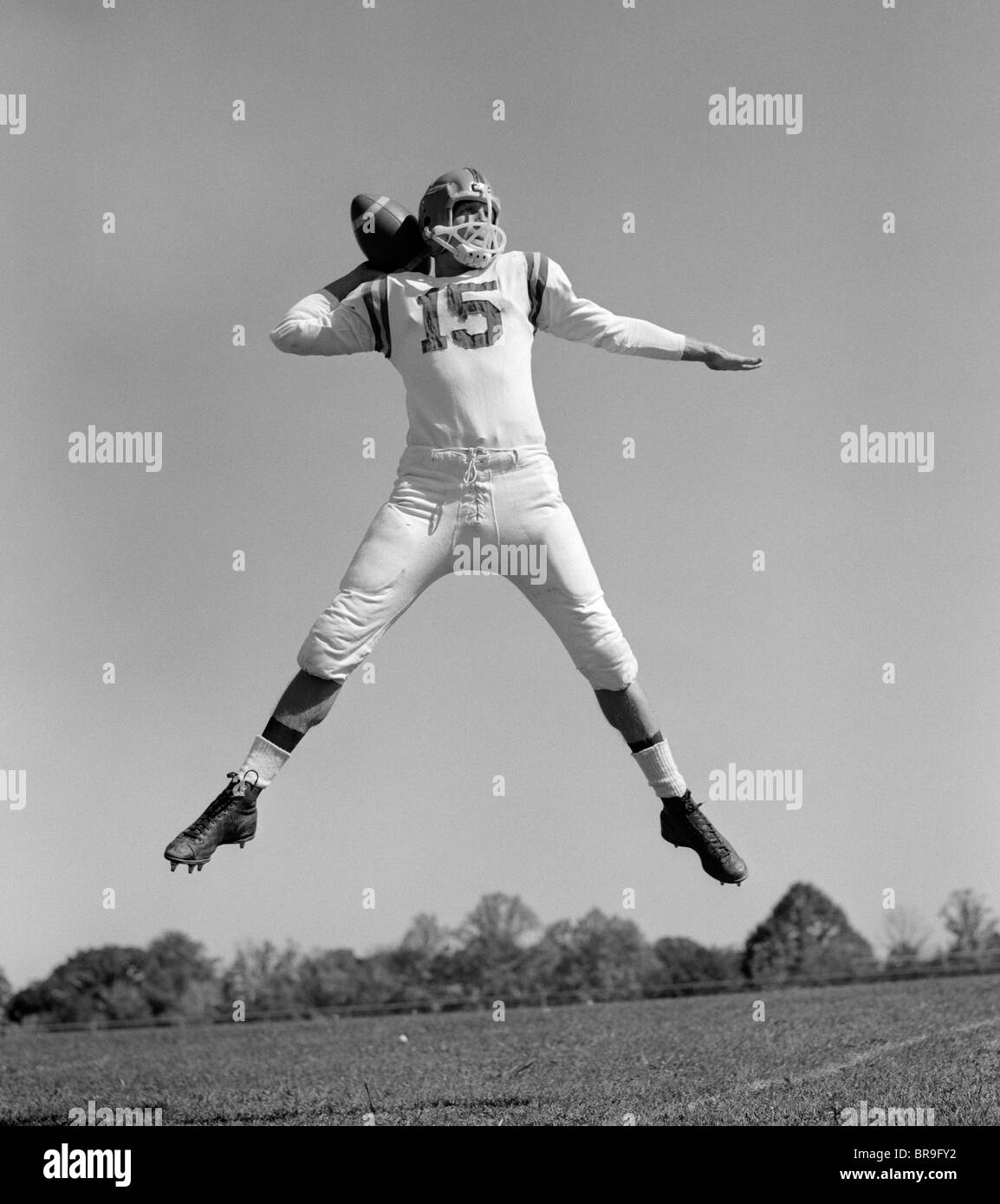 1960ER JAHREN QUARTERBACK SPRINGEN UND WERFEN PASS FUßBALL Stockfoto