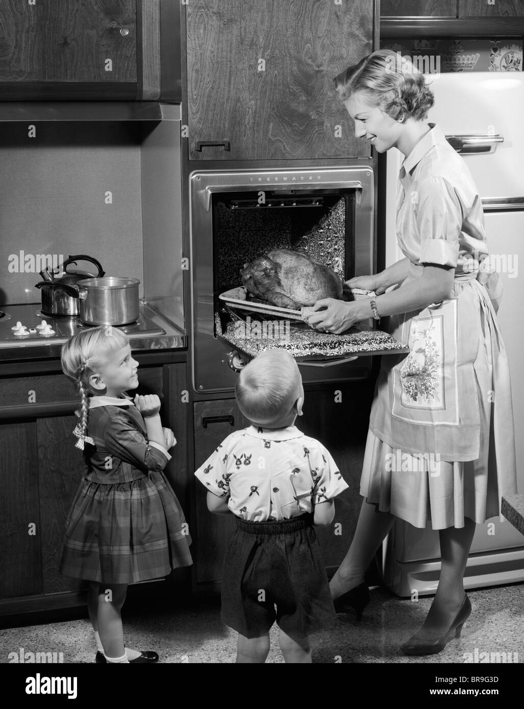 1950ER JAHRE TOCHTER UND SOHN BEOBACHTEN MUTTER ENTFERNEN BRATEN ...