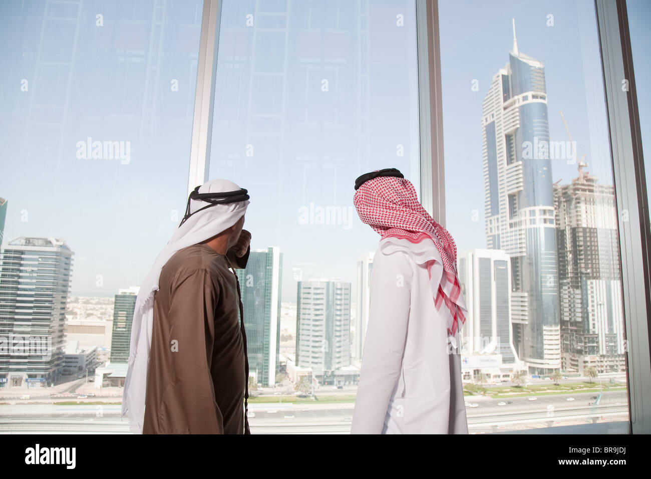 Nahen Osten Geschäftsleute Blick auf Dubai durch Bürofenster Stockfoto