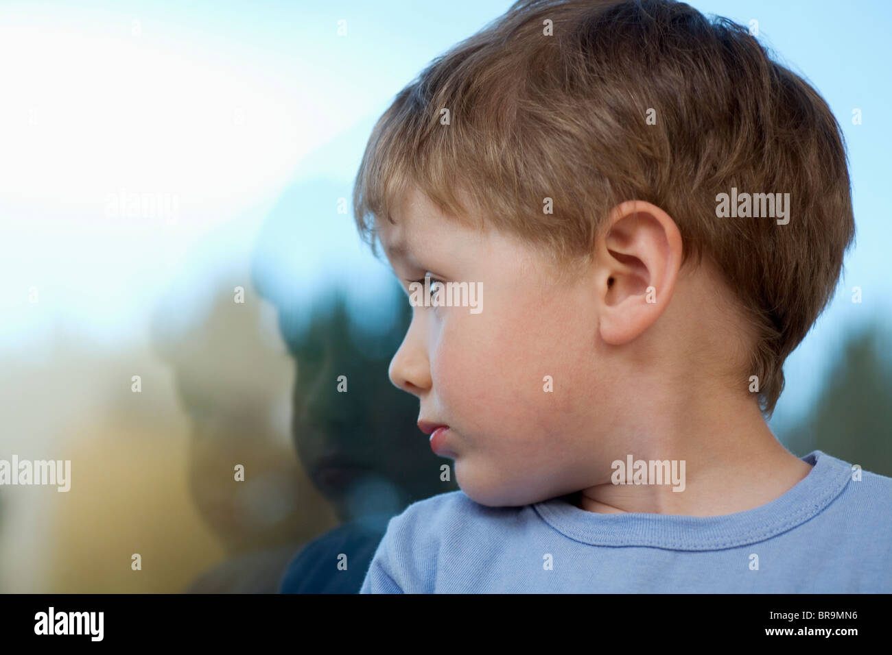 Kleiner Junge Rückblick auf Schatten im Glas Stockfoto
