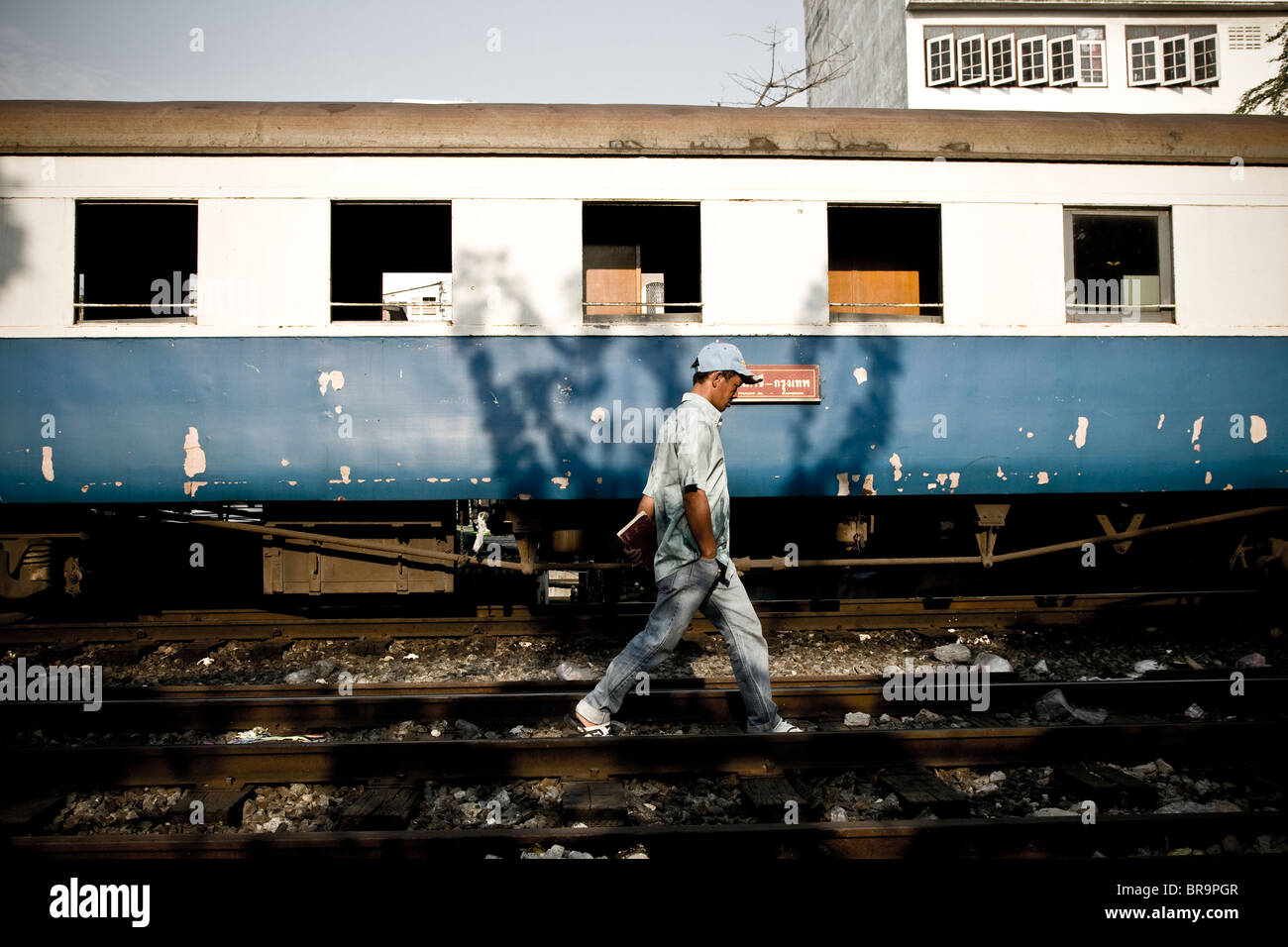 Ein Mann geht in den Slums von neben einem Zug. Stockfoto