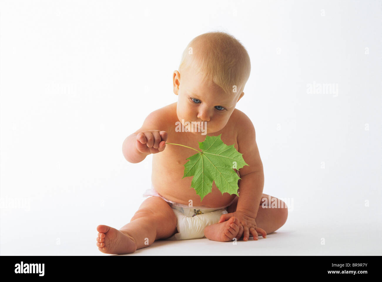 1990ER JAHRE BABY WINDEL HOLDING GRÜN BLATT Stockfoto